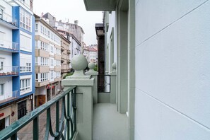 A narrow balcony with a green railing, overlooking a row of multi-story buildings with balconies and windows. - Limehome Santiago de Compostela (Santiago de Compostela)