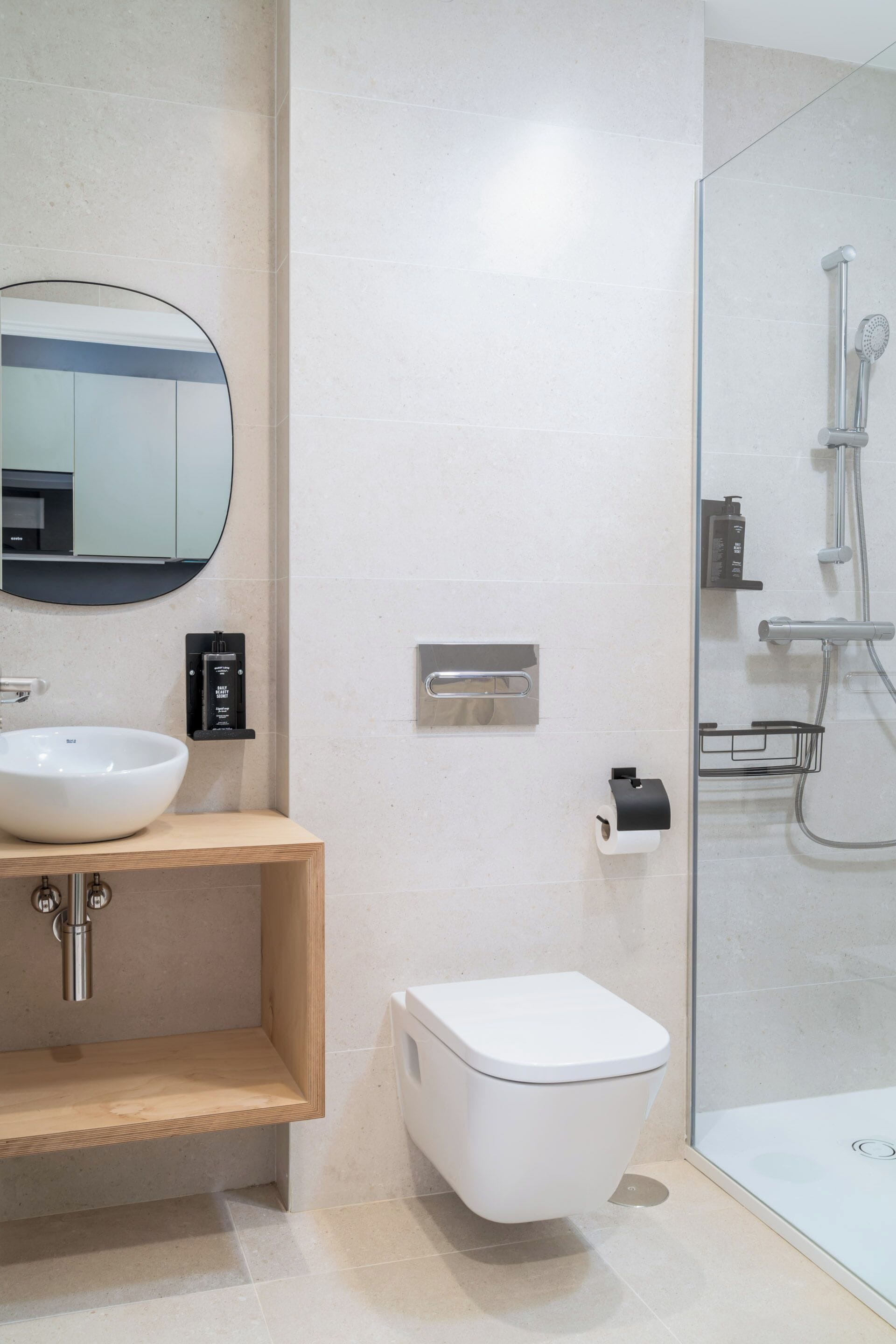 Een moderne badkamer met een wit wastafel, spiegel en toilet.