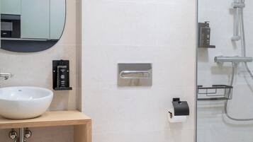 Een moderne badkamer met een wit wastafel, spiegel en toilet.