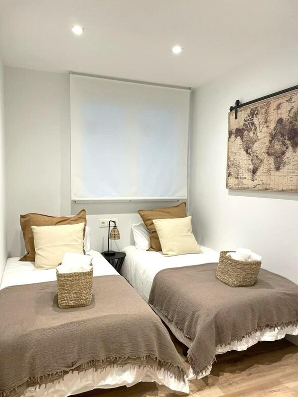 A hotel room with two beds, a world map on the wall, and a window with blinds. - Cosy Bilbao City Center Apartment - 2BR (Bilbao)