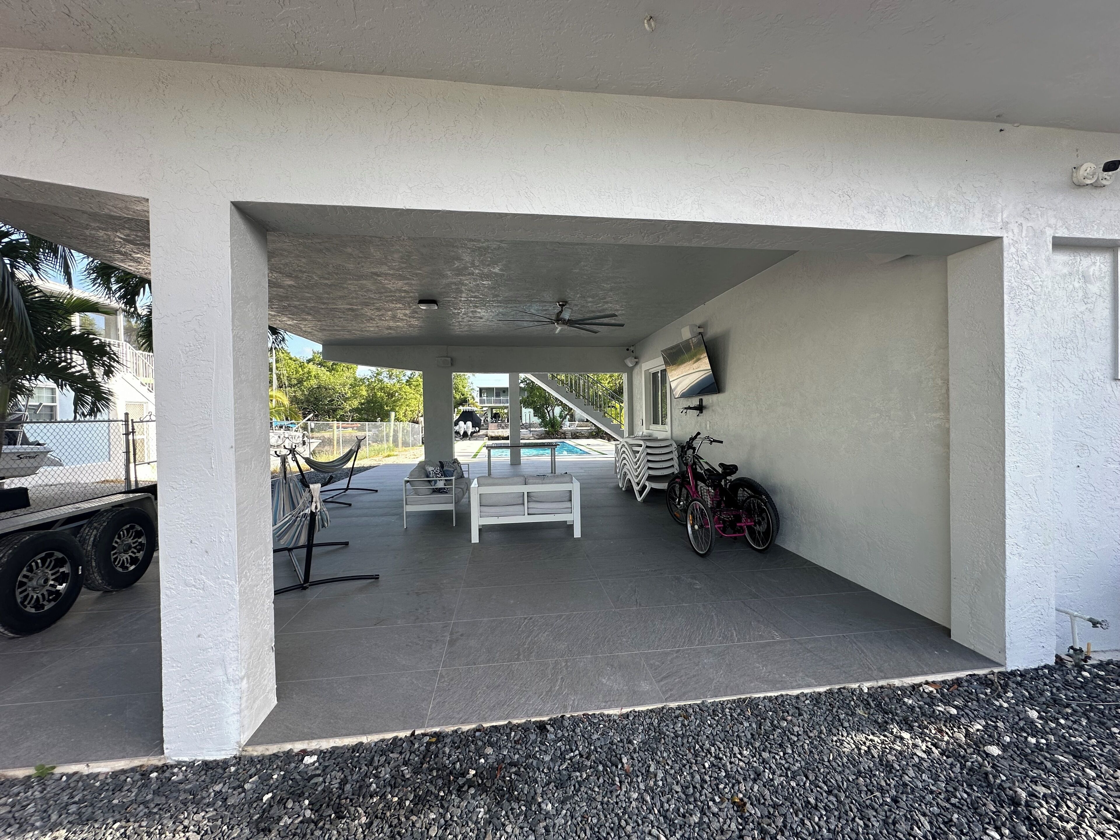 Ein überdachter Außenbereich mit Pool, Sitzgelegenheiten und einem Fahrrad.