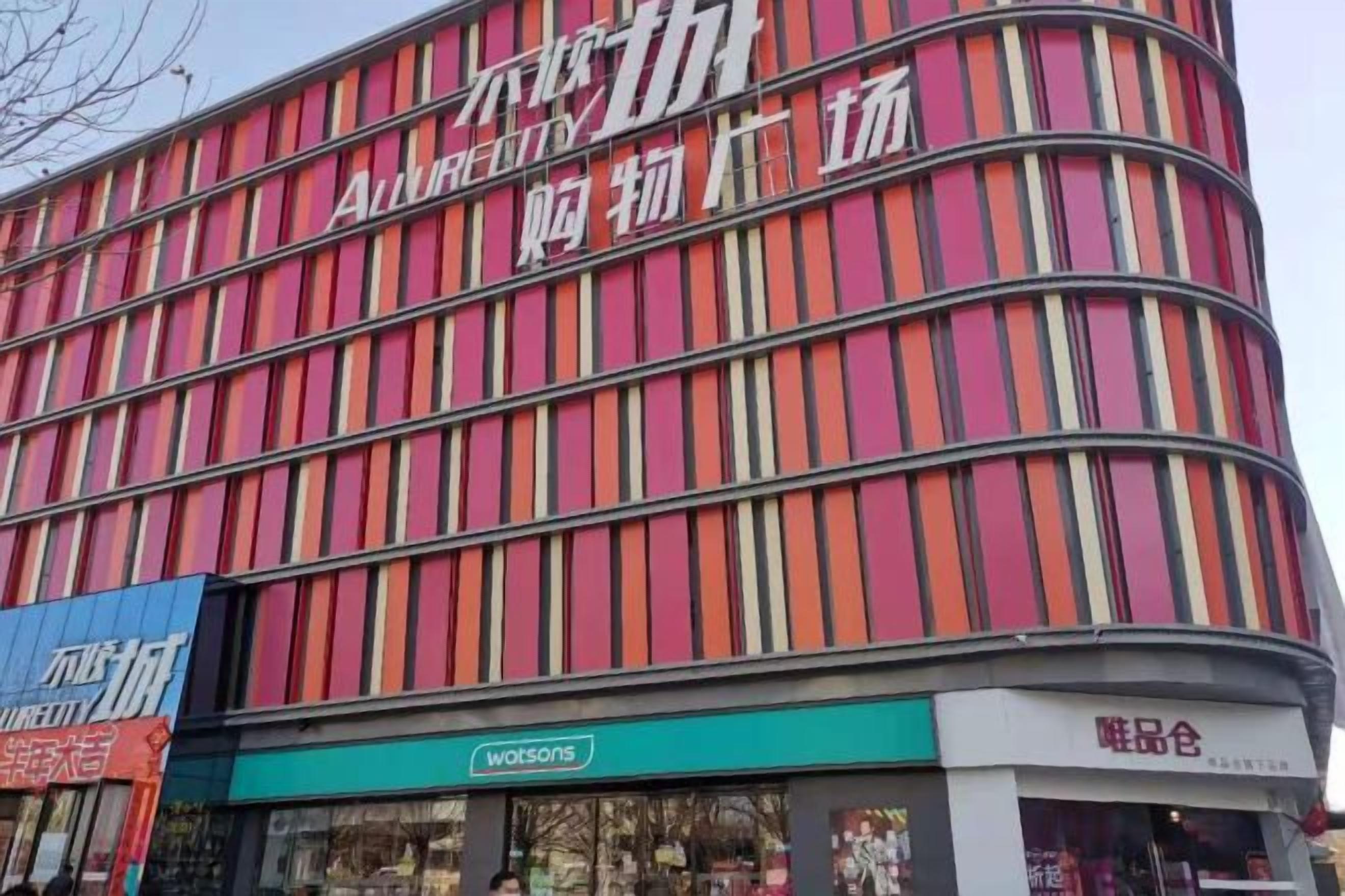 A multi-story building with a prominent sign for a store named 'Wotsons' on the ground floor.