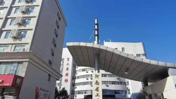 A building with a curved roof structure and a vertical sign with text.