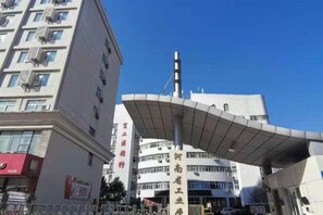 Un edificio con una estructura de techo curva y un letrero vertical con texto.