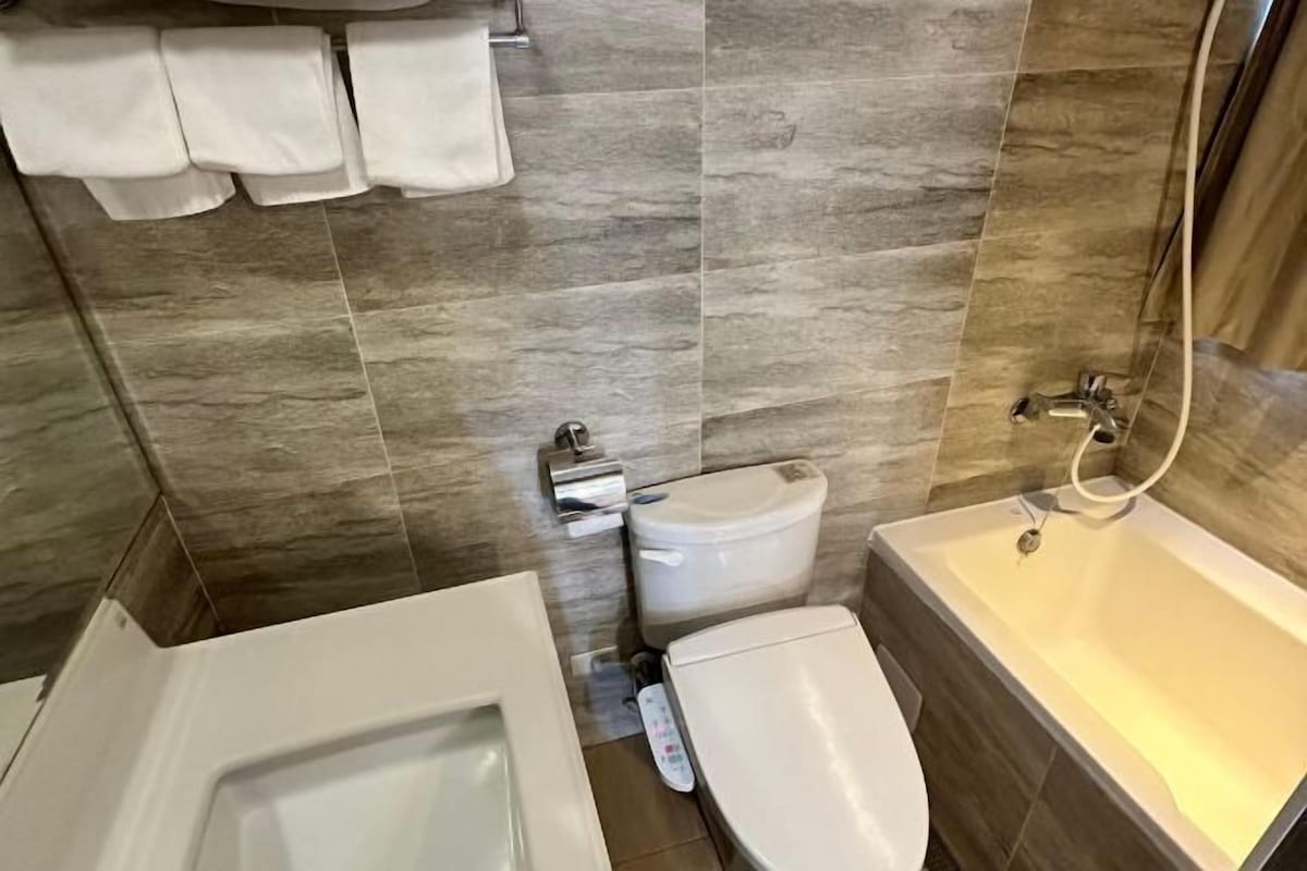 A bathroom with a bathtub, toilet, and sink.