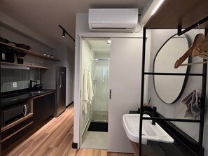 A modern kitchen with a built-in oven, a refrigerator, and a wooden countertop.