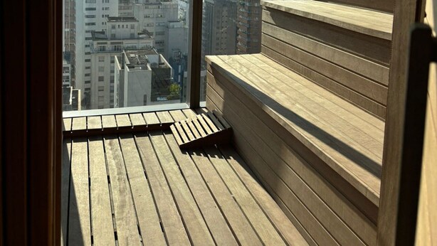 A high-rise building with a wooden deck and a city view. - Studio na avenida 9 de julho (São Paulo)