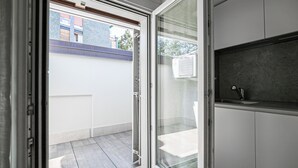 Ein modernes Badezimmer mit Duschabtrennung aus Glas, einem Waschbecken und einer dunklen Arbeitsplatte.