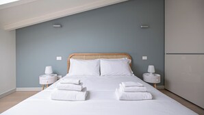A bedroom with a bed, two bedside tables, and a nightstand. - Volta 40 - A - One Bedroom Apartment, Sleeps 4 (Monza)