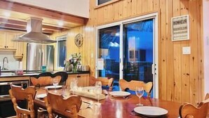 A dining area with wooden walls and a large window. There is a sign on the wall that reads "BONHEUR". - Family chalet and SPA near Mont Orford (Orford)