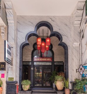 The entrance of 22LAND RESIDENCE HOTEL with a marble facade, red lanterns, and potted plants. - 22land 52 Ngo Huyen Hotel & Spa (Hanoi)