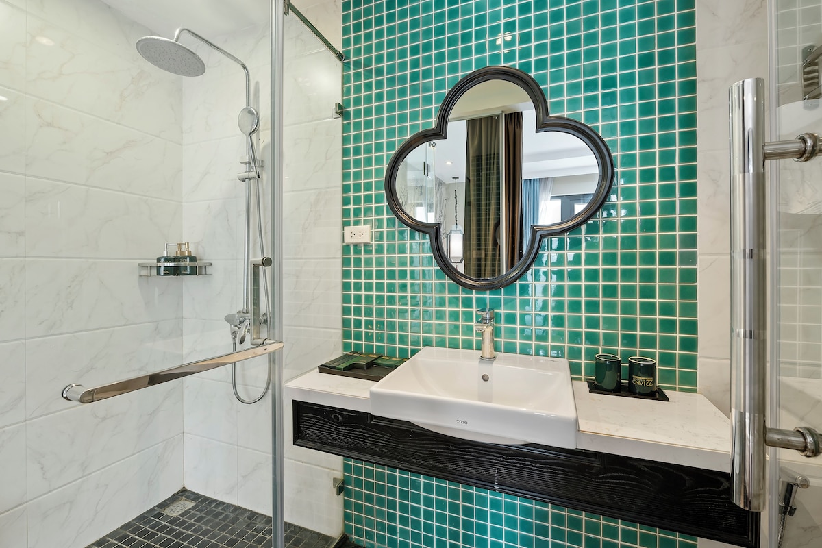 A bathroom with a white sink, a mirror, and a shower with a glass door.