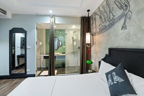 A hotel room with a bed, a nightstand, a lamp, a mirror, and a view into the bathroom. - 22land 52 Ngo Huyen Hotel & Spa (Hanoi)