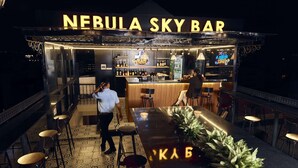 A bar named Nebula Sky Bar with a bar counter, stools, and a decorative plant. - 22land 52 Ngo Huyen Hotel & Spa (Hanoi)