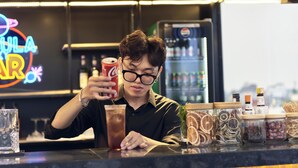 A person at a bar counter with a neon sign in the background. - 22land 52 Ngo Huyen Hotel & Spa (Hanoi)