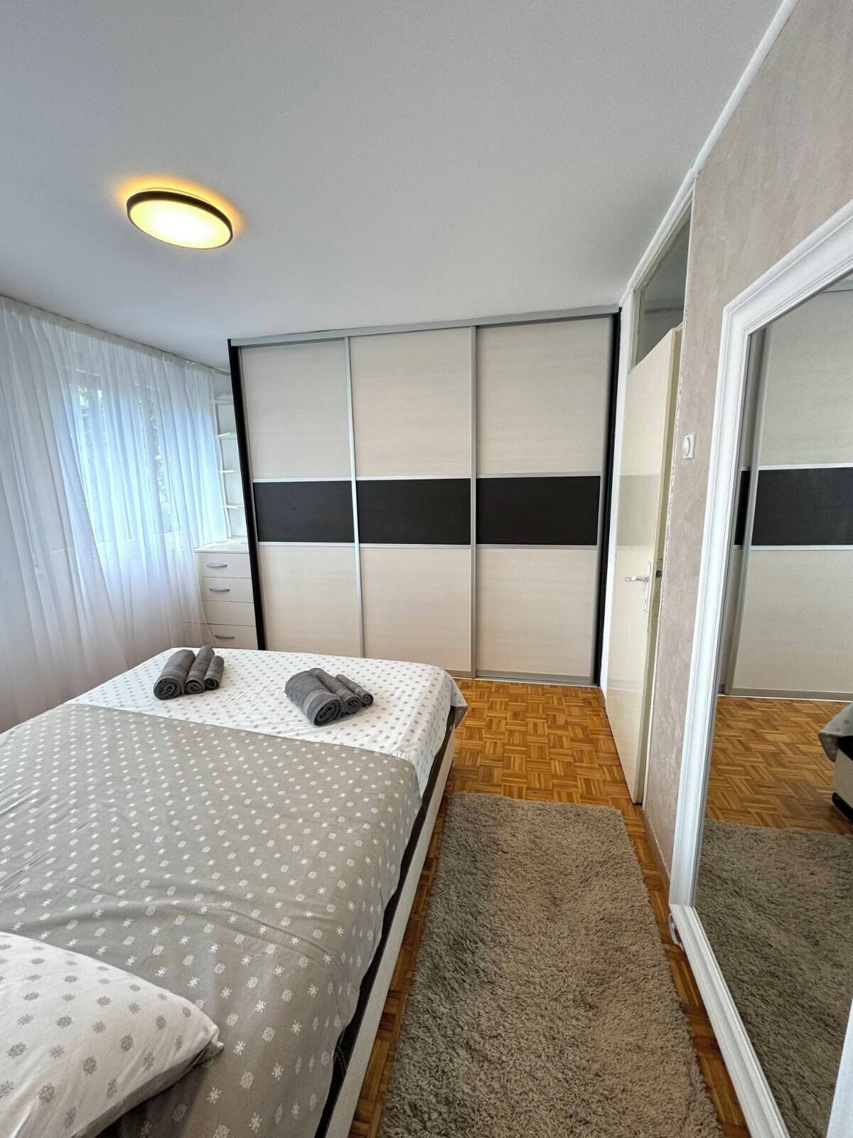 Un dormitorio con cama, armario y puerta corredera.