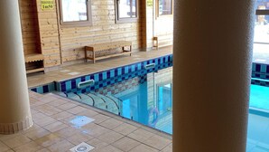 A pool area with tiled flooring, wooden walls, and a bench. - Apparemment sur les Pistes de ski Avec Piscine Risoul1850 Hautes Alpes (Risoul)
