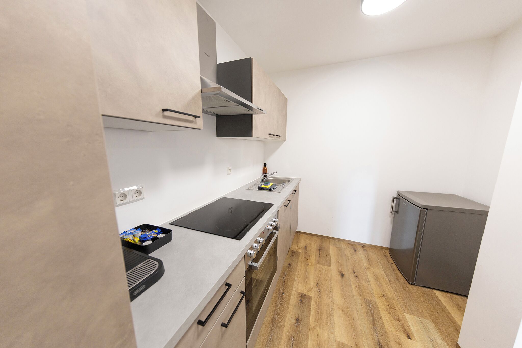 A compact kitchen with a built-in stove, oven, and microwave.