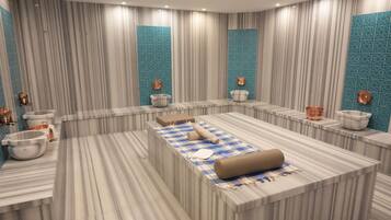 A modern bathroom with a large central bathtub, two sinks, and a vanity area.