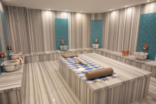 Un baño moderno con una bañera grande en el centro, dos lavamanos y una zona de tocador.
