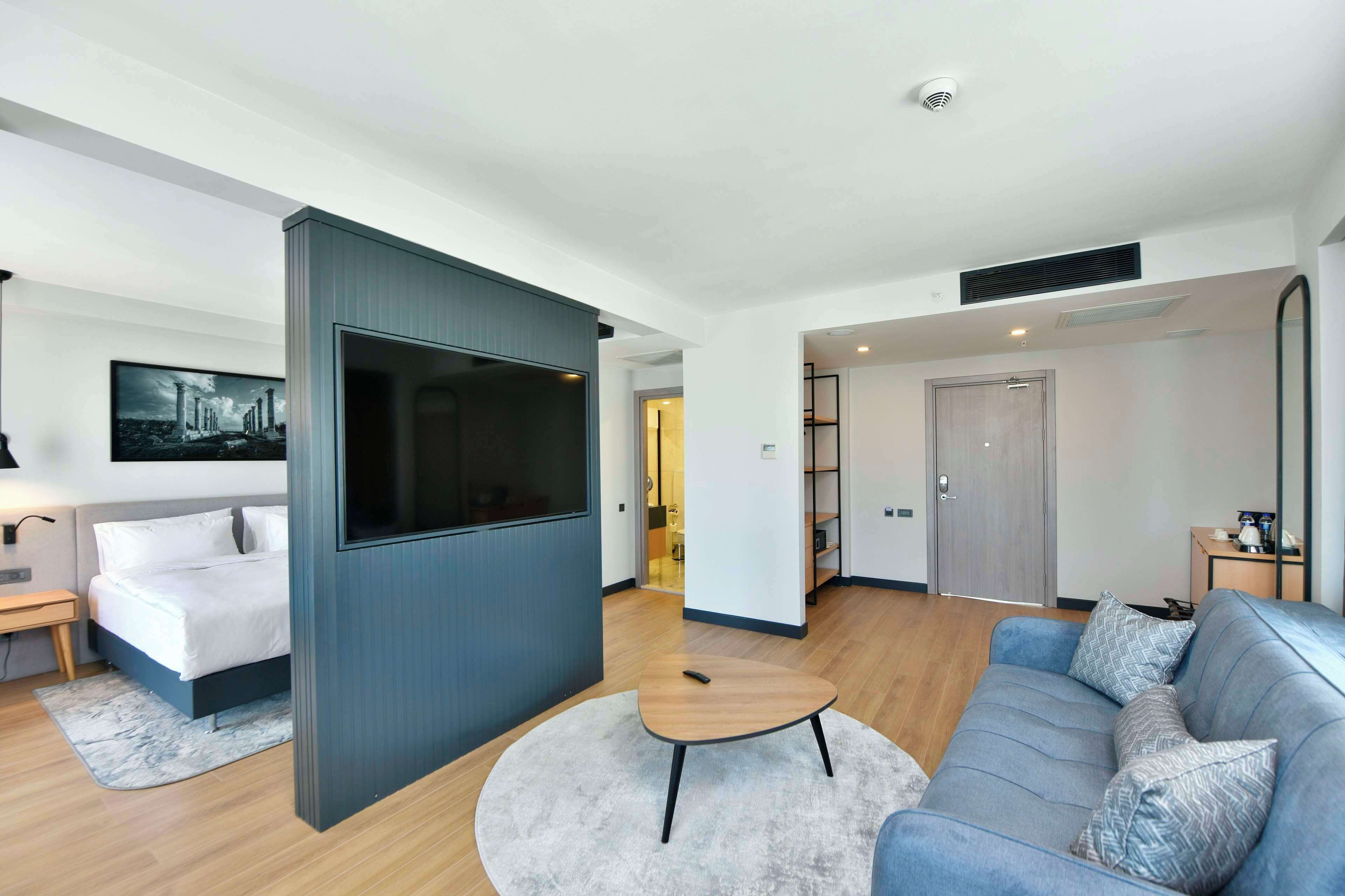 A modern living room with a sofa, a coffee table, and a TV.