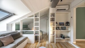A compact, modern room with a loft bed, built-in shelving, and a skylight. - Lake view attic  (Dagnente)