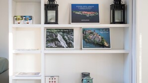 A white shelving unit with books, a coffee machine, and decorative items. - Lake view attic  (Dagnente)