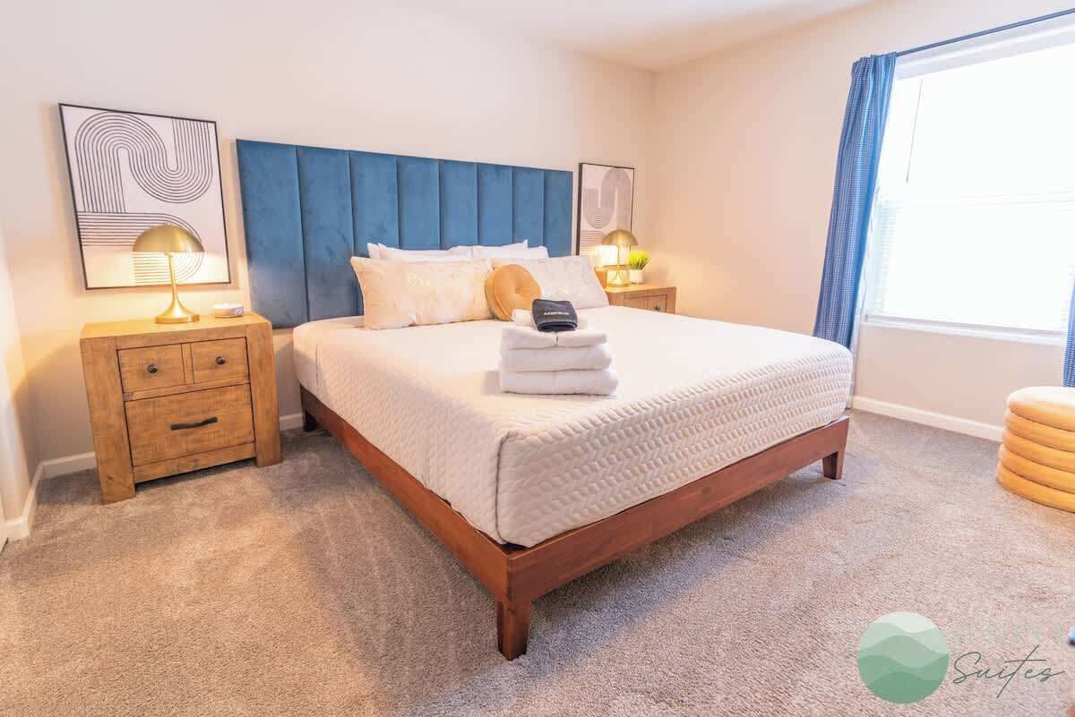 A neatly arranged bedroom with a bed, two bedside tables, and a nightstand.