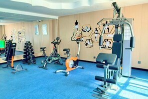 A gym with various exercise equipment, including stationary bikes, treadmills, and weight machines. - Friendship Peak Hotel (Burqin)
