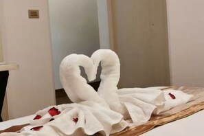 Ein Zimmer mit einem Bett, einem Holzkopfteil und einem an der Wand befestigten Lichtschalter.