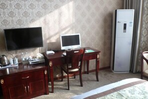 A hotel room with a wooden desk, a television, a computer, a refrigerator, and a bed. - Century Business Hotel (Meitan)