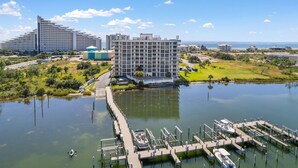 A modern hotel with a marina, docked boats, and a view of the sea. - Seaspray Riverside 313 (Pensacola)