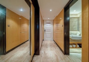 A hallway with wooden doors and a bathroom visible to the right.