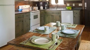A kitchen with wooden cabinets, a refrigerator, microwave, stove, and a sink.