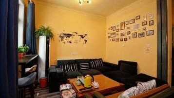 Uma sala de estar com sofá, mesa de centro e um mapa-múndi na parede.