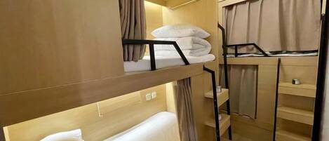A bunk bed room with a desk and a small shelf.