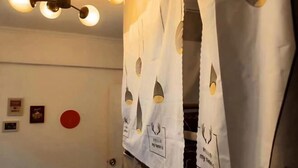 A bathroom with a towel hanging on a rack, a red circular decoration on the wall, and a ceiling light fixture. - Reverse Time Youth Hostel (Nanjing Station South Square Branch) (Nanjing)