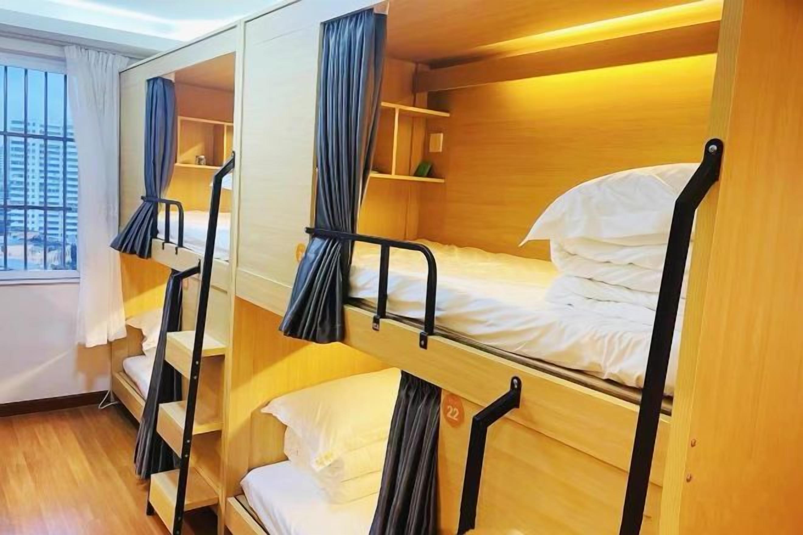 Quarto com beliches, paredes de madeira e uma janela.