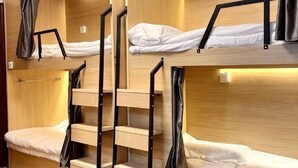 A bunk bed room with wooden walls, metal railings, and a small table. - Reverse Time Youth Hostel (Nanjing Station South Square Branch) (Nanjing)