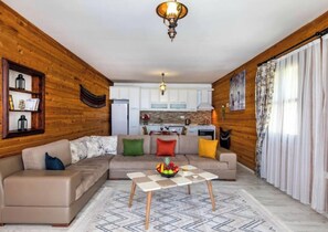 Relax in this inviting living room with a large L-shaped sofa and a kitchen area.