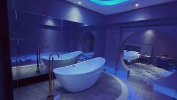 A modern bathroom with a freestanding bathtub, a mirror, and a shower.