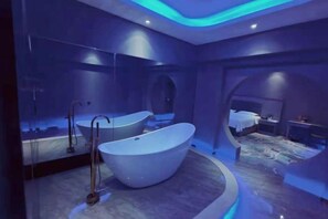 A modern bathroom with a freestanding bathtub, a mirror, and a shower. - Xidun Hotel (Chenzhou)