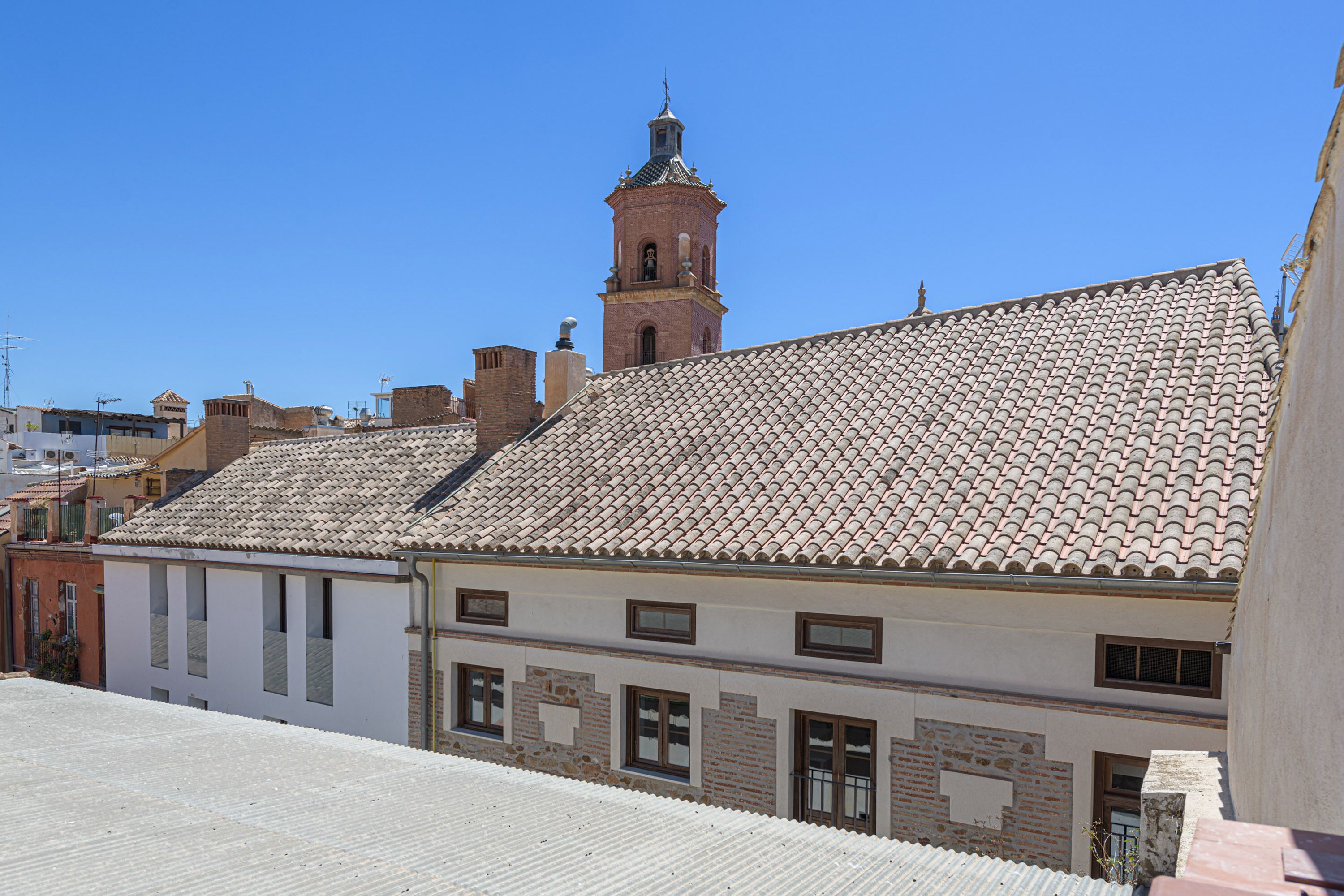 Un edificio con techo de tejas y un campanario.