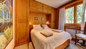A wooden room with a bed, a chair, and a window. - Meters from the lift station with a private terrace and balcony in Verbier (Val de Bagnes)