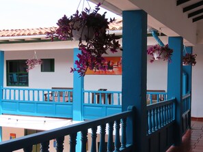 A balcony with blue railings and hanging purple flowers. - Celeste Villa de Leyva (Villa de Leyva)