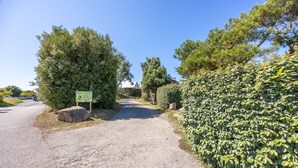 A gravel path leading to a building with a sign that reads "Maison de la Pâtisserie." - Marée Basse - Studio proche plage de la potinière (Barneville-Carteret)
