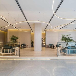 A modern lobby with a central column, seating areas, and a glass partition. - Atour S Hotel Wenshu Yuan MonasterySubway Station, Chunxi Road (Chengdu)