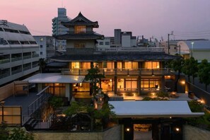 A traditional Japanese building with a tiled roof, multiple levels, and a central courtyard. - ANABUKI-TEI (Takamatsu)