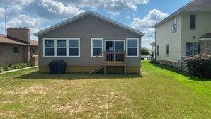 Einbungalow mit Veranda, überdachter Grillstelle und kleinem Garten.