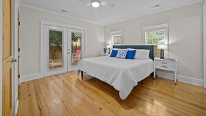 A bedroom with a bed, a nightstand, a ceiling fan, and a window. - The Cottage in Little Washington (Washington)